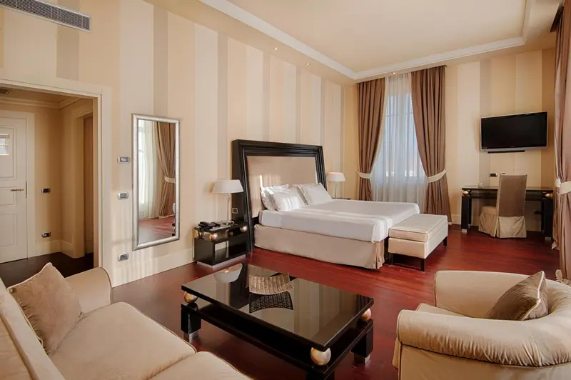 Une chambre spacieuse avec un grand lit et un coin salon.