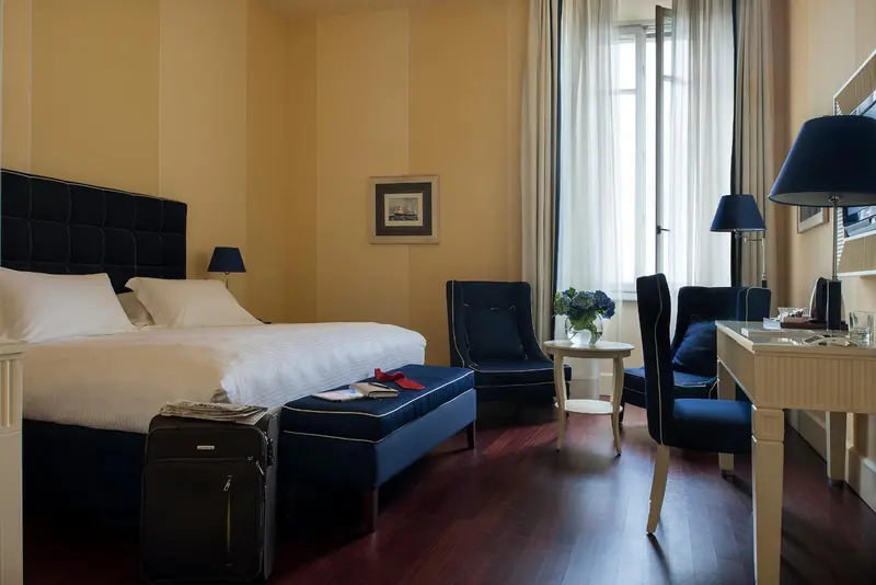 Une chambre lumineuse avec un grand lit et un coin salon.