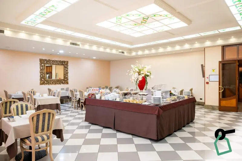 Une salle lumineuse avec des tables dressées pour un buffet.