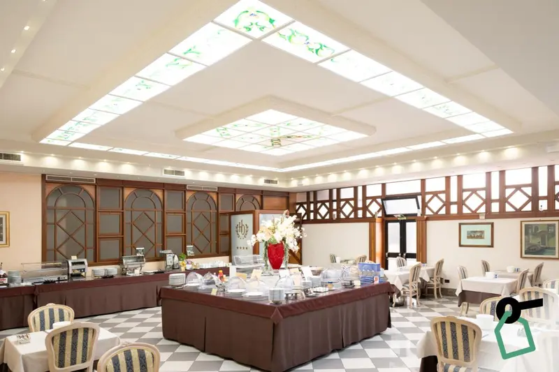 Une salle lumineuse avec des tables dressées pour un buffet.