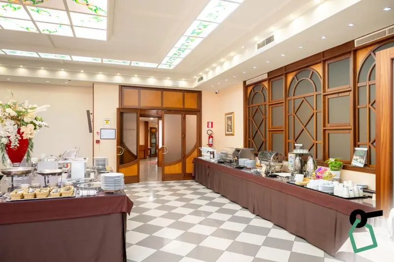 Une salle lumineuse avec un buffet garni et des tables disposées sur un sol carrelé.