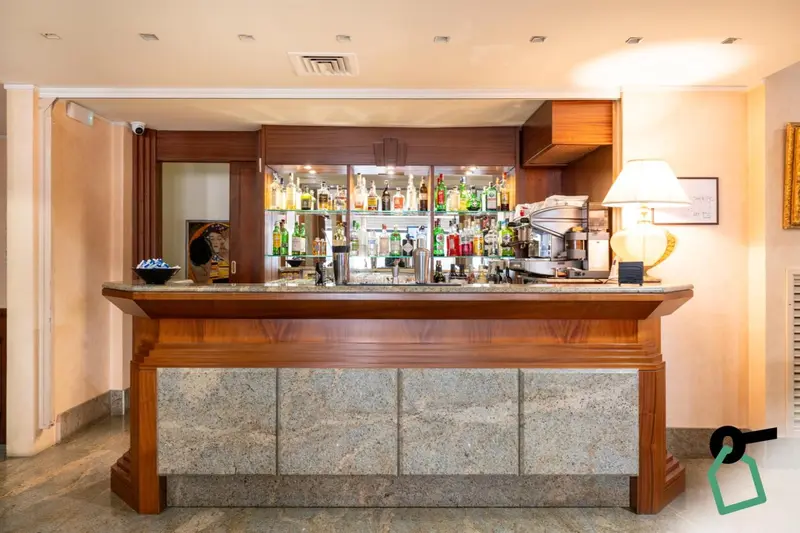 Un comptoir de bar en bois avec des bouteilles et des verres.