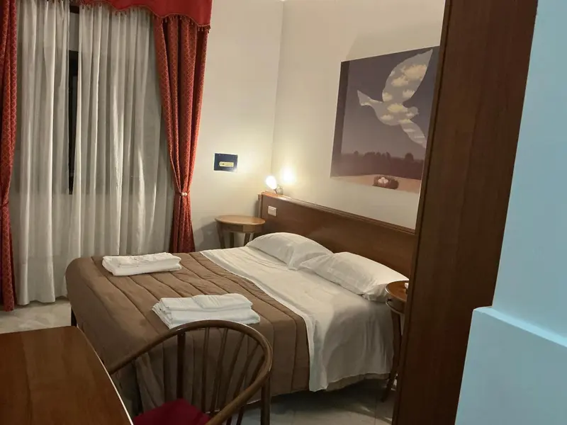 Une chambre avec un lit double et une décoration murale.