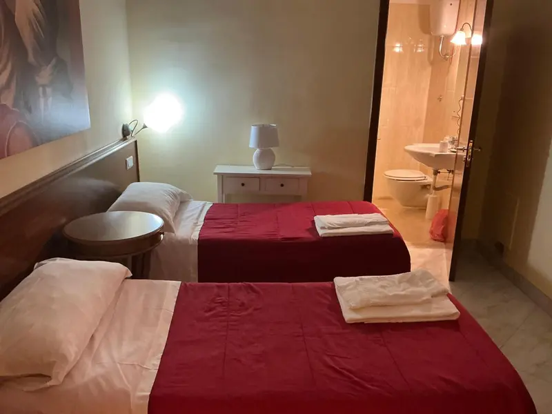 Une chambre avec deux lits et une salle de bain attenante.