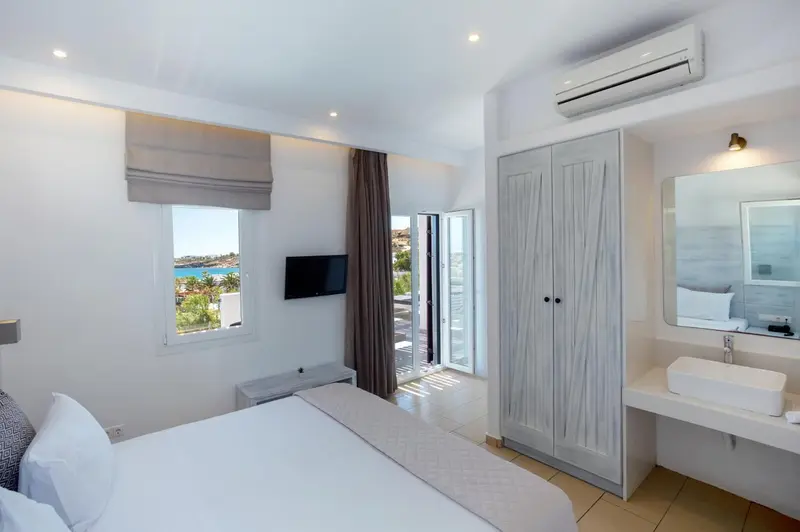 Une chambre lumineuse avec un grand lit et un accès à une terrasse.