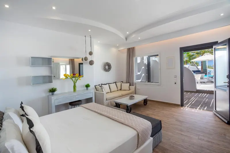 Une chambre lumineuse avec un canapé et un accès à une terrasse.