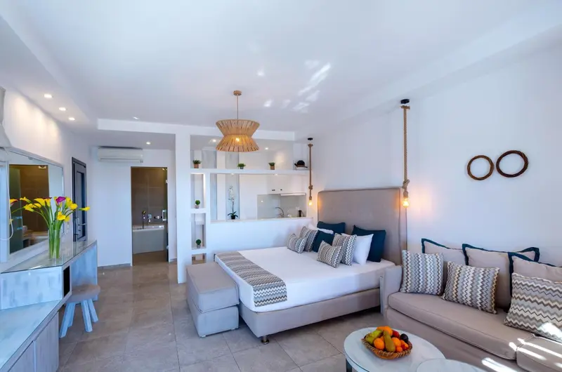 Une chambre lumineuse avec un grand lit et un coin salon.