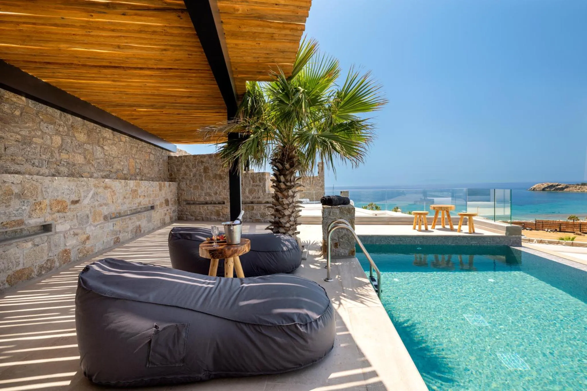 Espace détente extérieur avec assises confortables et piscine à débordement face à la mer.