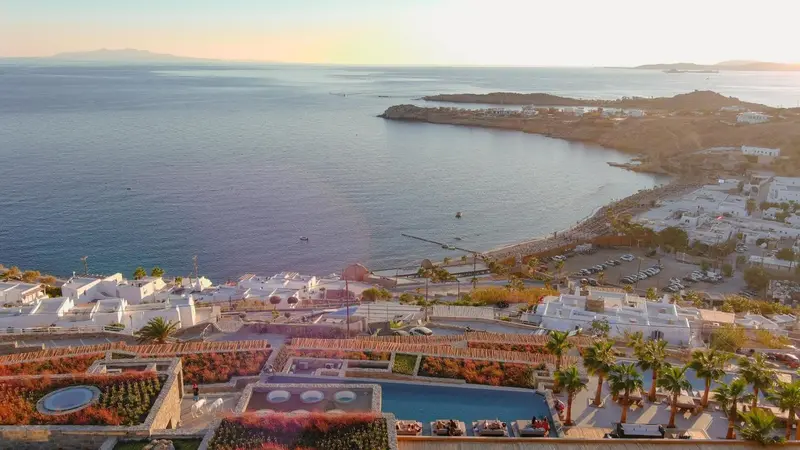 Vue aérienne d'une côte rocheuse avec des bâtiments blancs et une piscine.