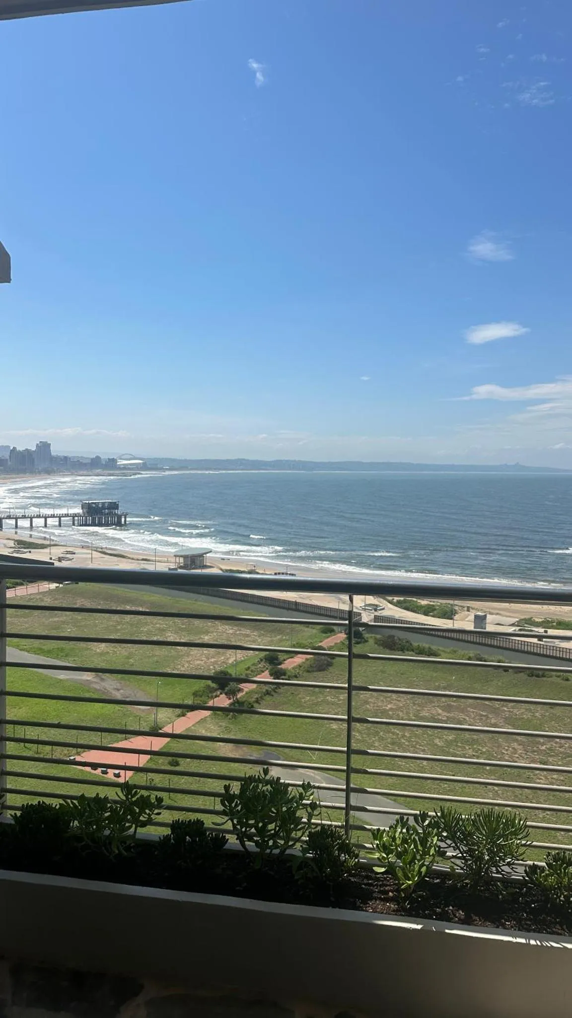 Vue dégagée sur la mer et la plage depuis un balcon.