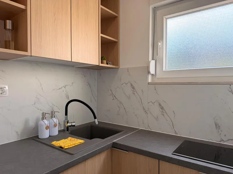 Une cuisine moderne avec un plan de travail gris et des armoires en bois.