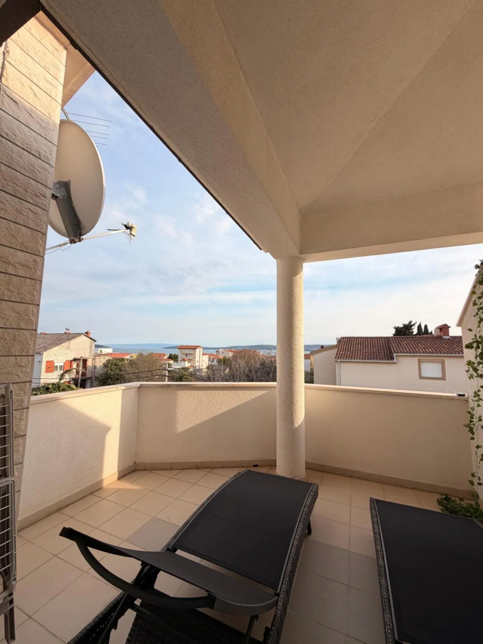 Terrasse avec transats et vue sur la mer et les environs.