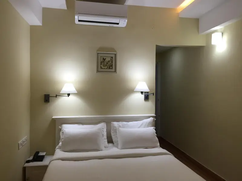Une chambre lumineuse avec un lit double et des appliques murales.