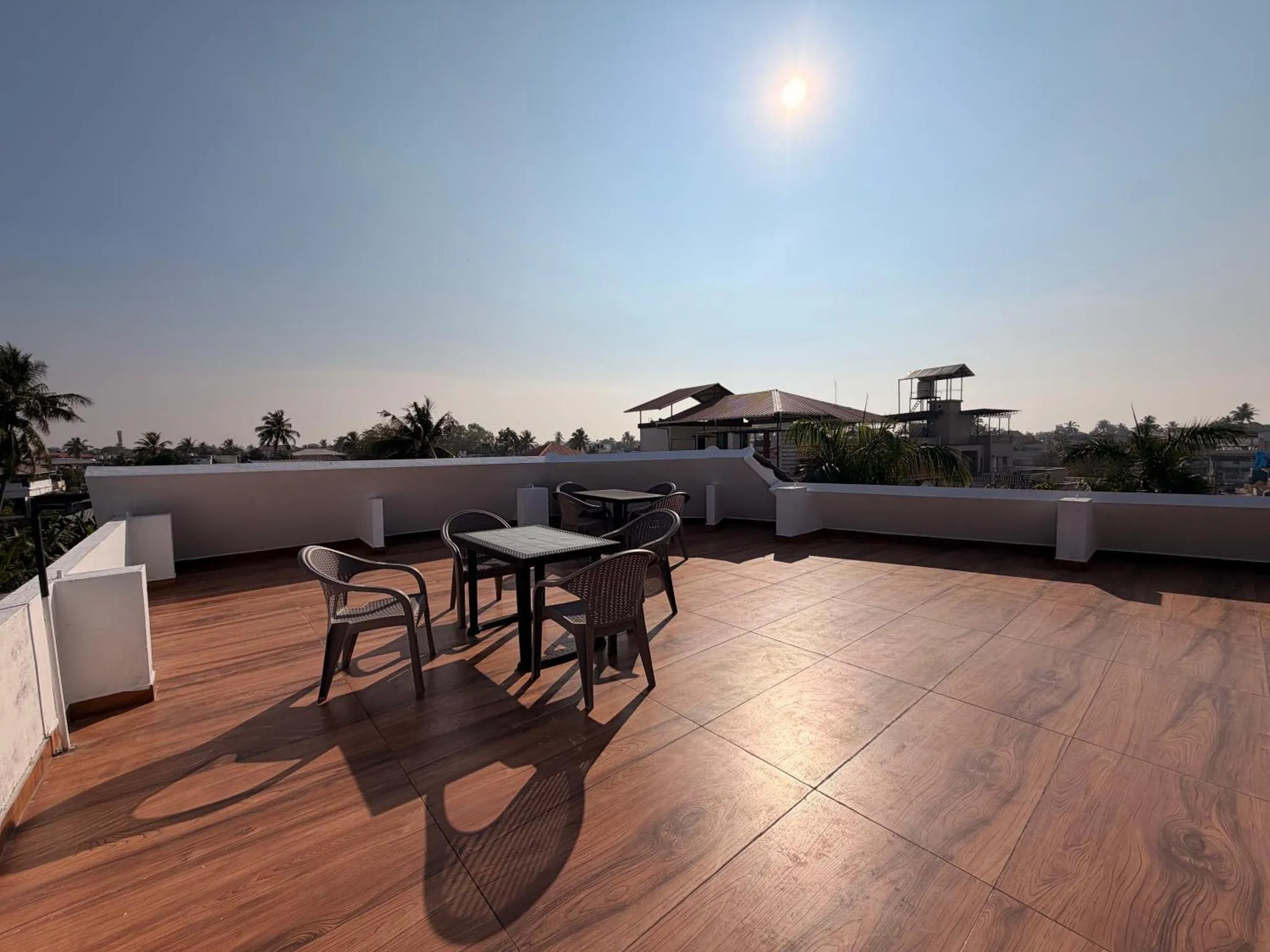 Terrasse aménagée avec tables et chaises sous un ciel bleu dégagé.