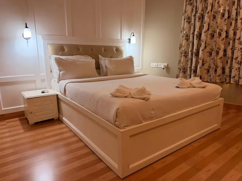 Une chambre lumineuse avec un grand lit recouvert d'une courtepointe blanche.