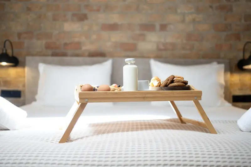 Un petit-déjeuner est servi sur un plateau posé sur un lit.