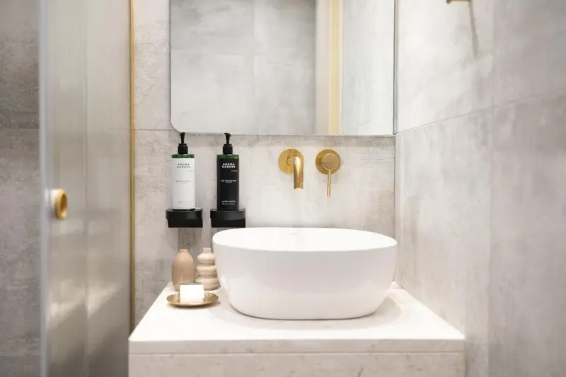 Un lavabo blanc sur un meuble clair dans une salle de bain moderne.