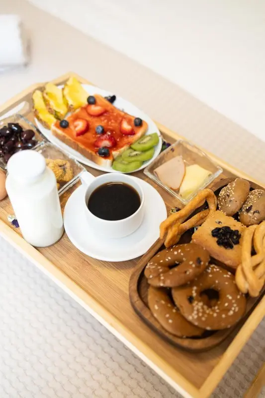 Un plateau de petit-déjeuner avec des fruits, des viennoiseries et une boisson chaude.