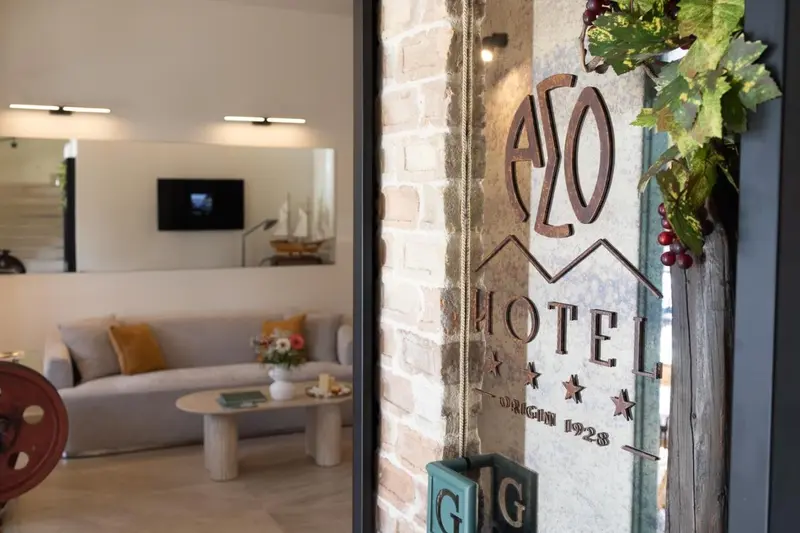 Un salon d'hotel avec un canapé et une table basse, éclairé par des spots.
