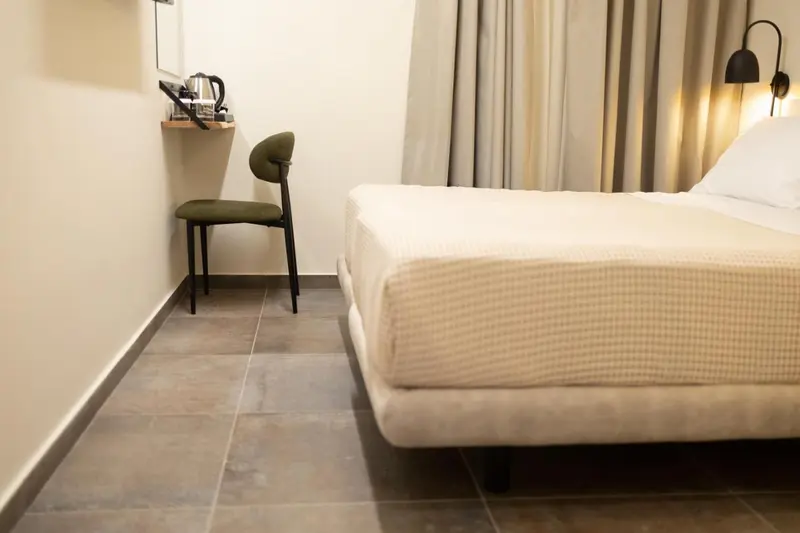 Une chambre d'hôtel lumineuse avec un lit et un coin bureau.