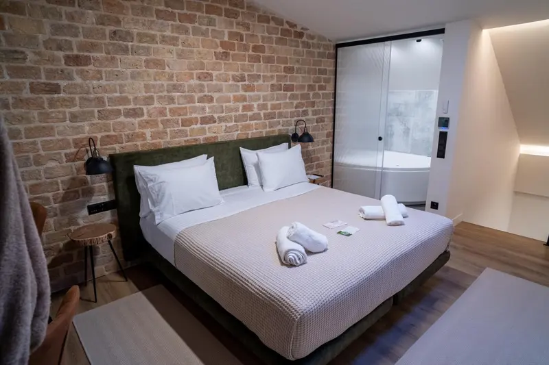 Une chambre avec un grand lit et une baignoire à débordement.