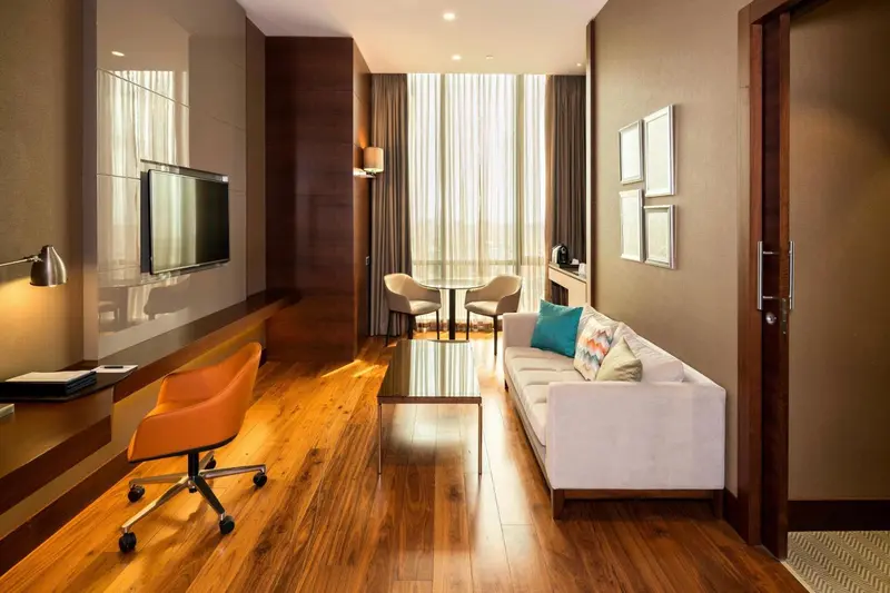 Espace de vie intérieur lumineux avec canapé, table basse et bureau.