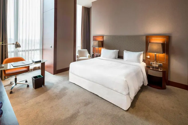 Chambre moderne avec un grand lit et un espace bureau.