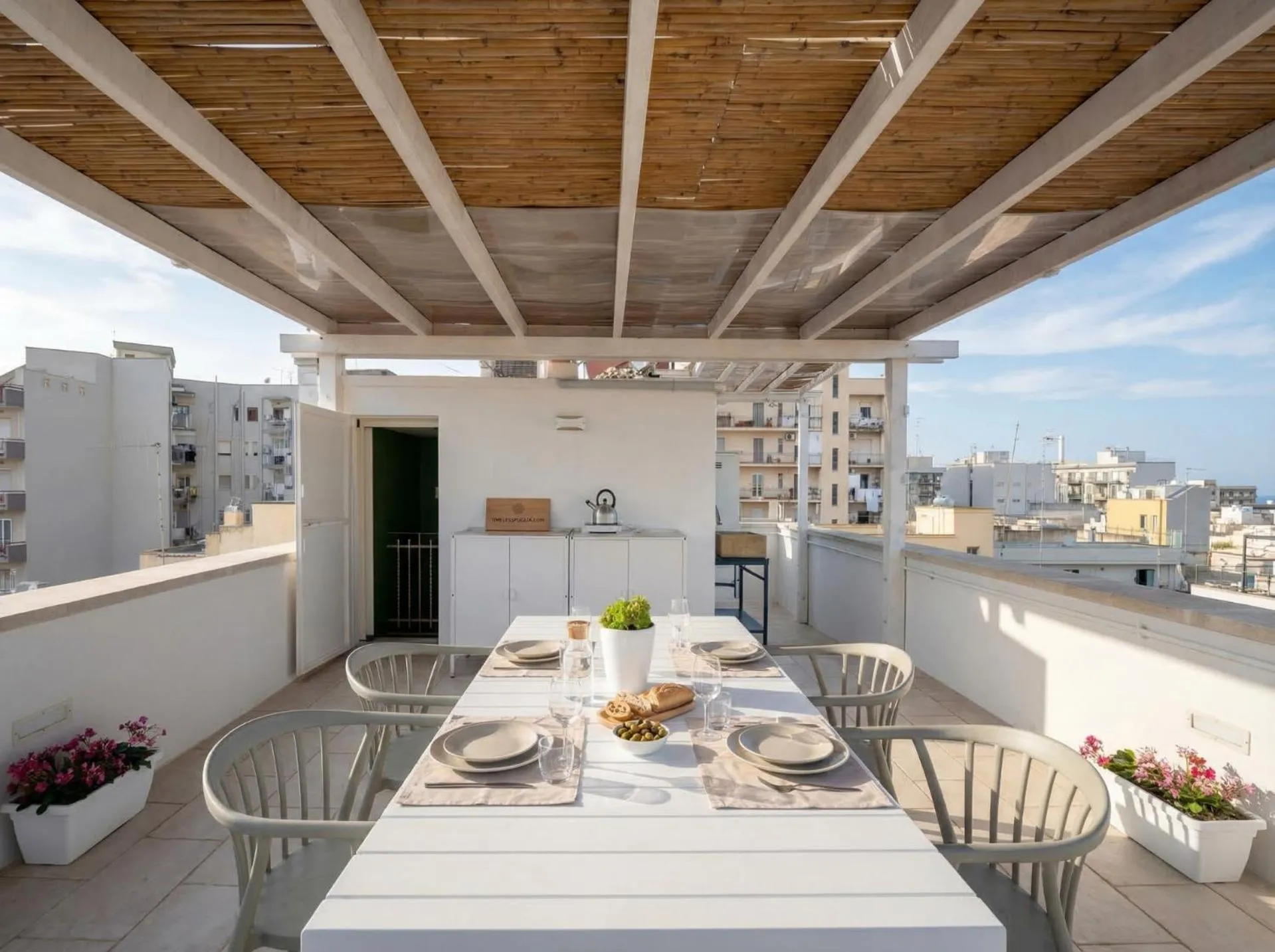 Une table à manger est mise en scène sur une terrasse ombragée.