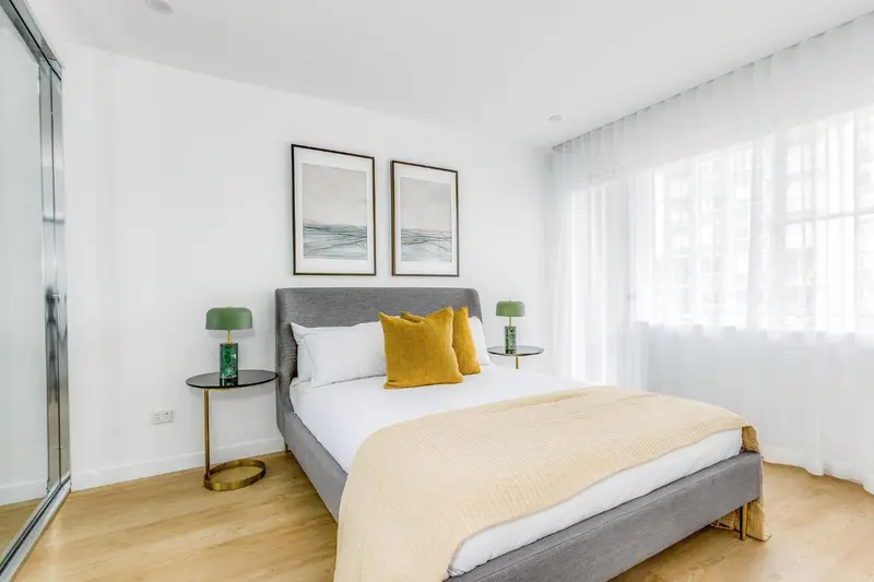 Une chambre lumineuse avec un grand lit et des tables de chevet.