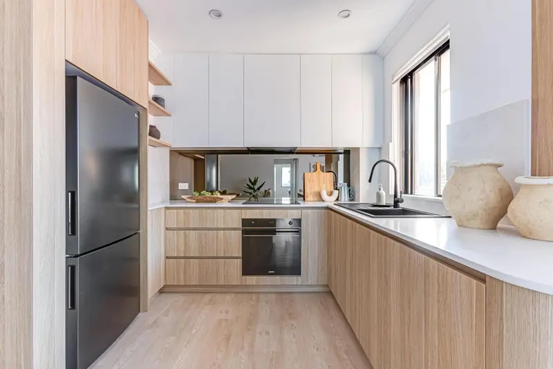 Cuisine moderne avec des armoires en bois et un plan de travail clair.