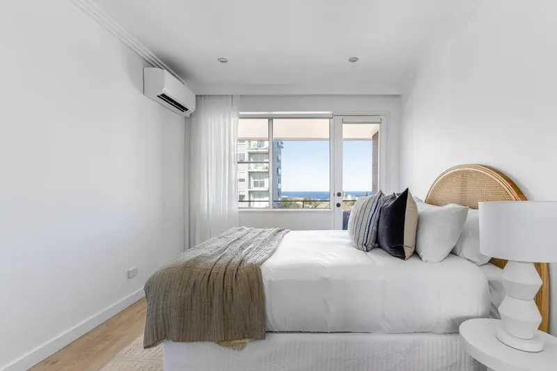 Une chambre lumineuse avec un grand lit et une vue sur la mer.