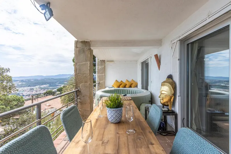 Terrasse avec table à manger et vue sur la ville.