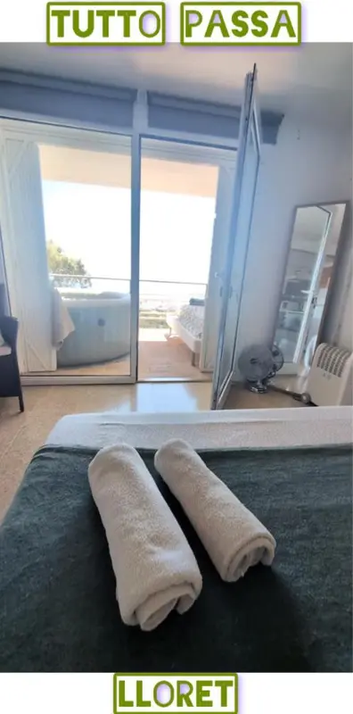 Une chambre avec un lit preparé donnant sur une terrasse et une vue sur la mer.