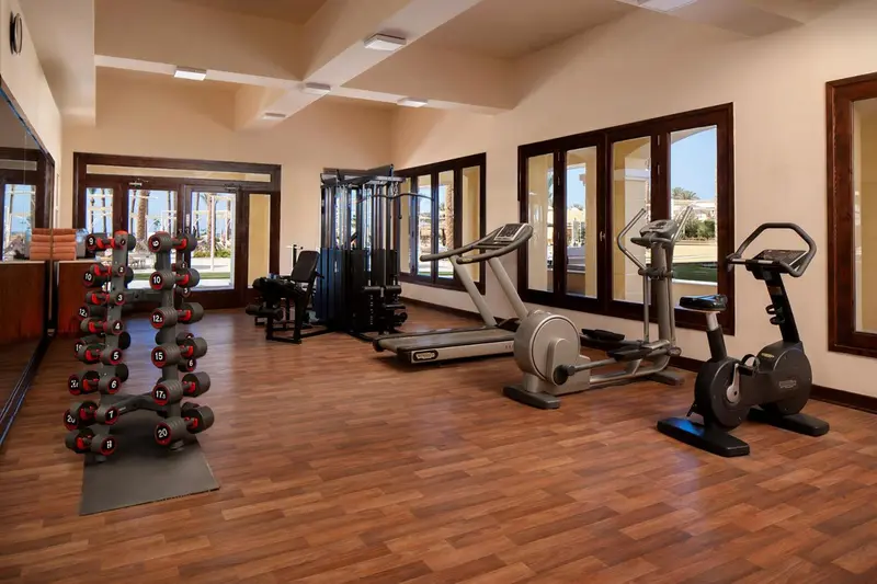 Une salle de sport lumineuse avec des équipements de musculation et cardio.