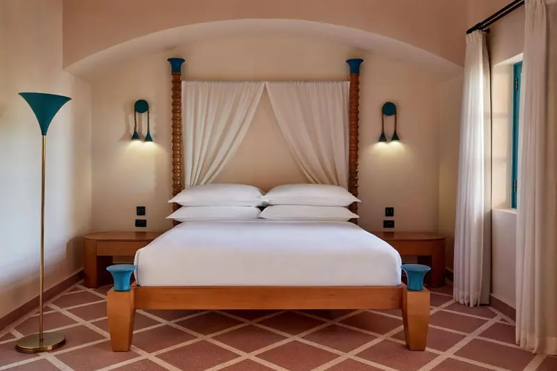 Une chambre lumineuse avec un grand lit à baldaquin.