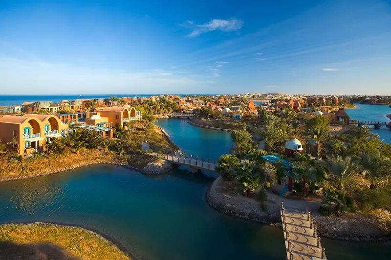 Vue aérienne d'un complexe hôtelier bordant une lagune turquoise.