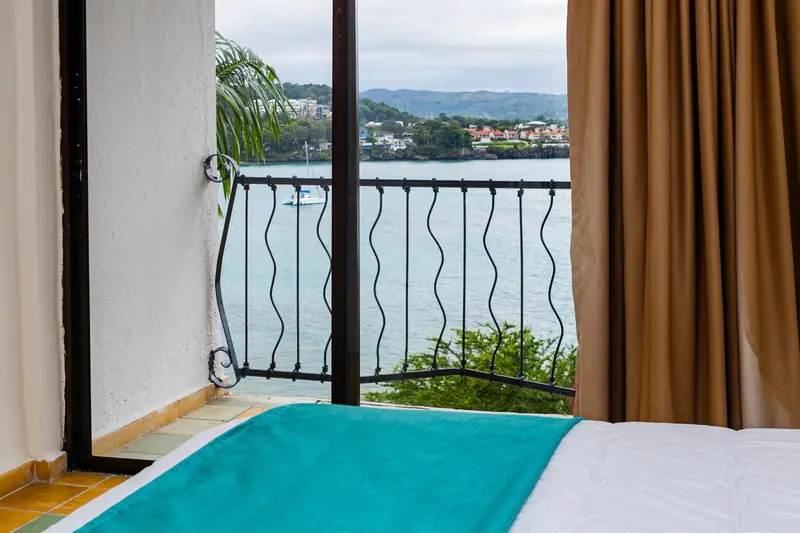 Vue sur la mer depuis un balcon avec un lit en premier plan.