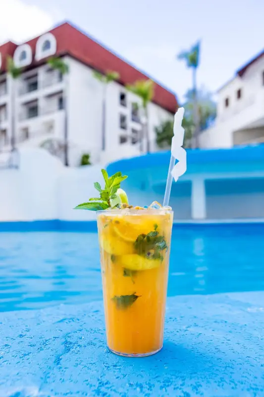 Un cocktail exotique rafraîchissant au bord d'une piscine turquoise.