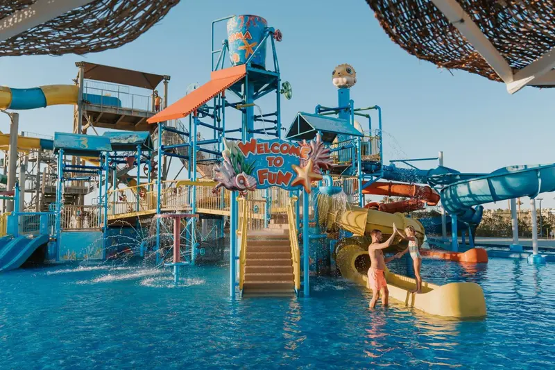 Un parc aquatique avec des toboggans colorés et une structure de jeux pour enfants.