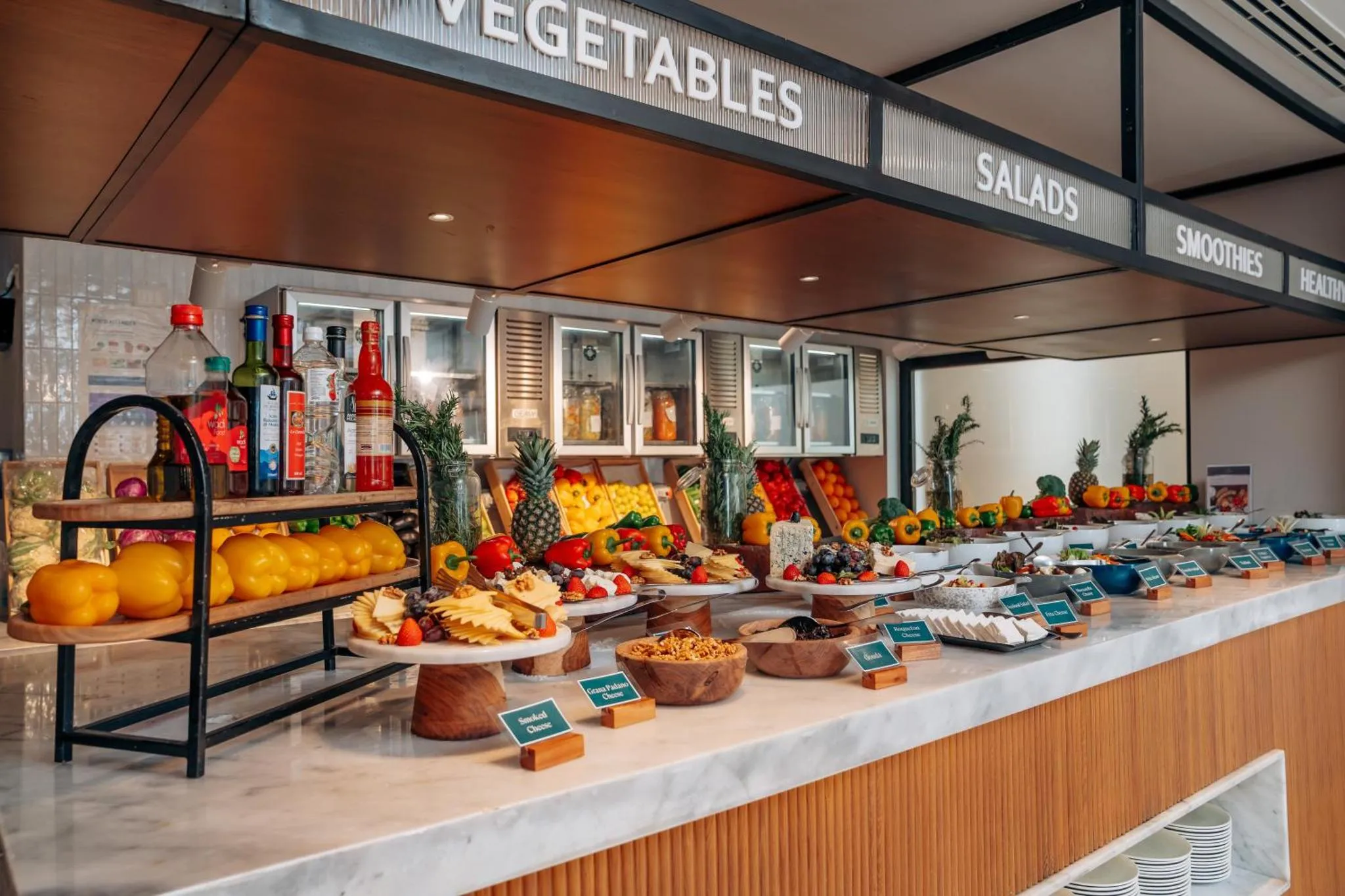 Un buffet propose une variété de fruits, de salades et de boissons.