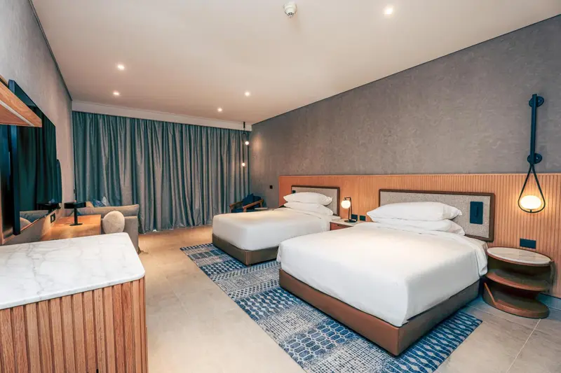 Chambre moderne avec deux lits simples et une décoration soignée.