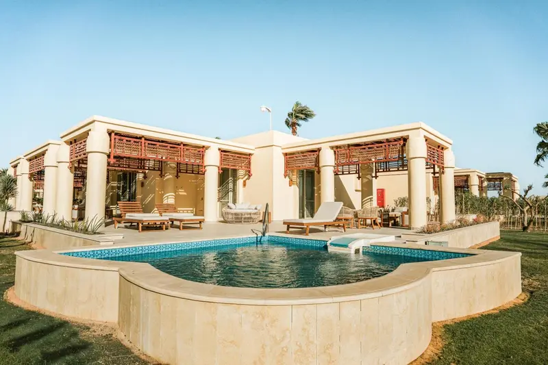 Bâtiment beige avec terrasses et petite piscine privée.