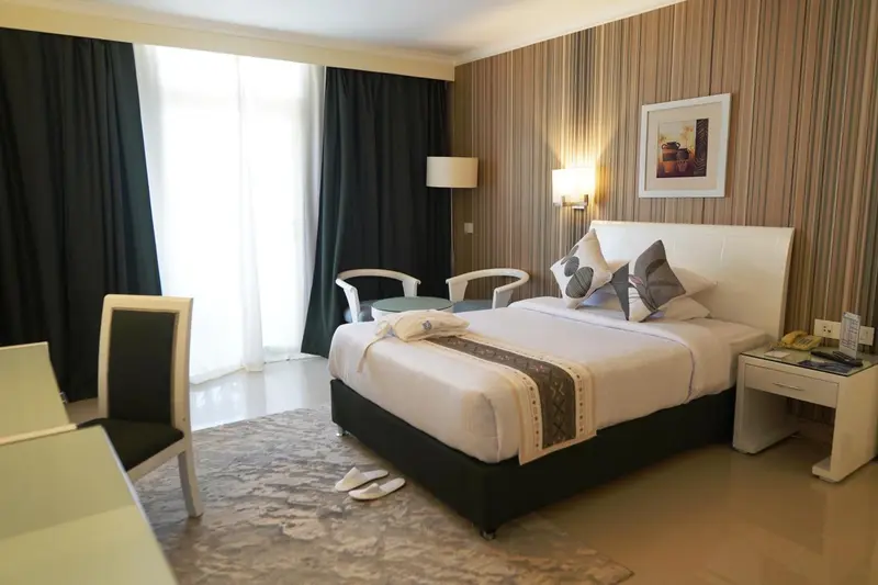 Une chambre lumineuse avec un grand lit et un mobilier moderne.