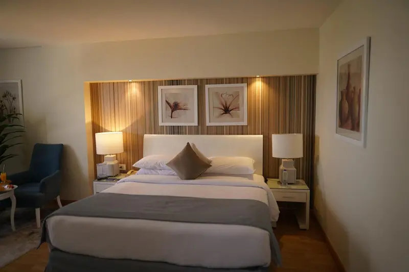Une chambre lumineuse avec un grand lit et des tables de chevet.