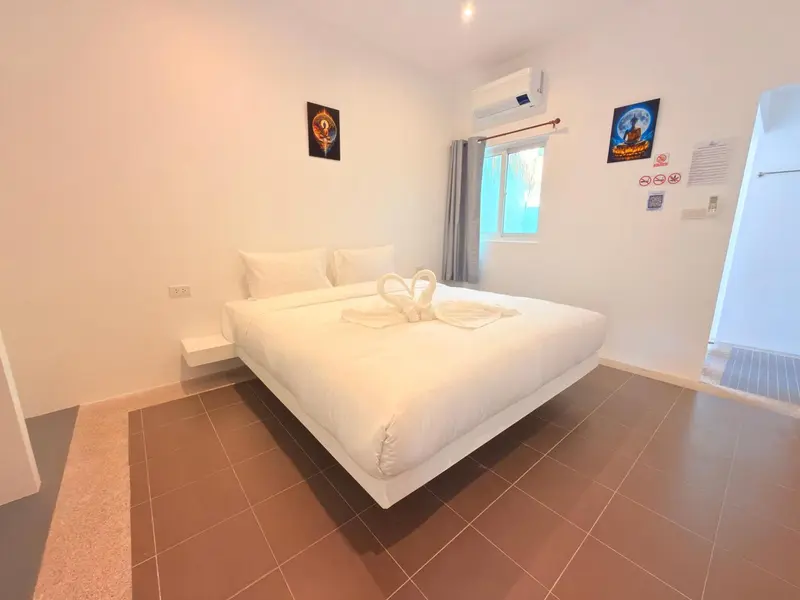 Une chambre lumineuse avec un grand lit recouvert de draps blancs.