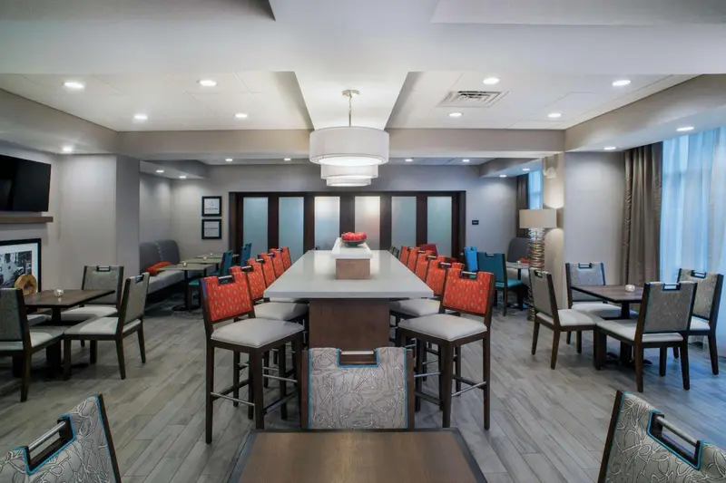 Une salle lumineuse avec de longues tables et des chaises confortables.