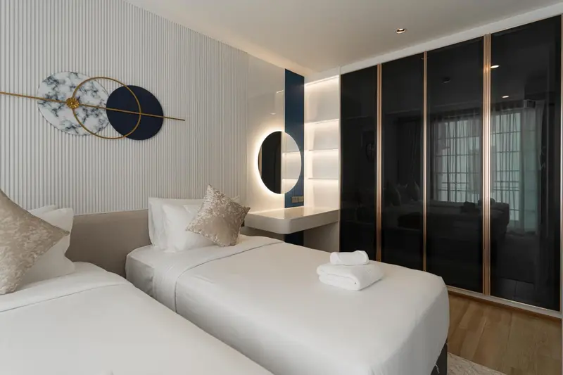 Chambre moderne avec deux lits simples et décoration murale.