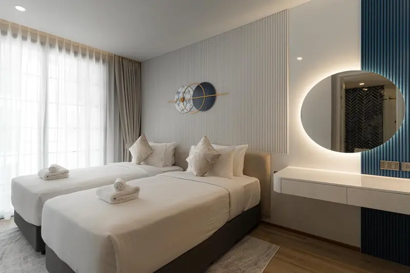 Une chambre lumineuse avec deux lits simples et un décor moderne.