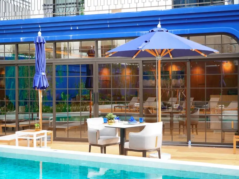 Terrasse avec mobilier de jardin et vue sur un espace intérieur lumineux.