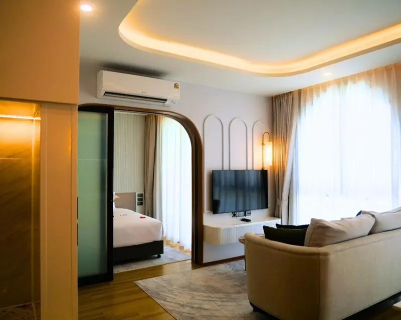 Espace de vie lumineux avec canapé et chambre à coucher.